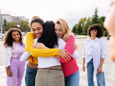 A group of women embrace in a hug | Wahl & Holland